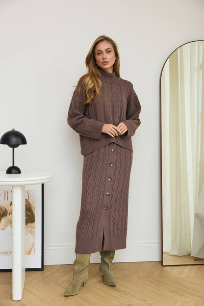 Woman wearing a brown cable knit dress standing in front of a mirror.