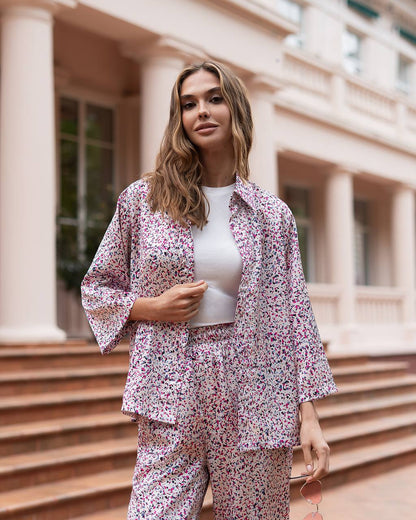 Woman wearing a floral outfit standing on steps in front of a building
