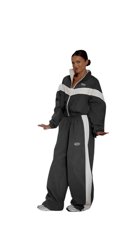 Person wearing a black and gray jumpsuit with white stripes on a white background