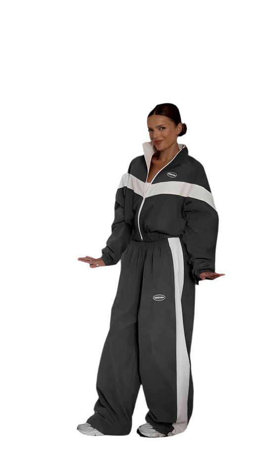 Person wearing a black and gray jumpsuit with white stripes on a white background