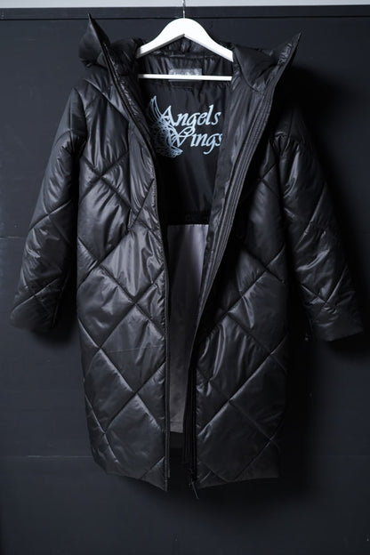 Black quilted jacket on a hanger against a dark background