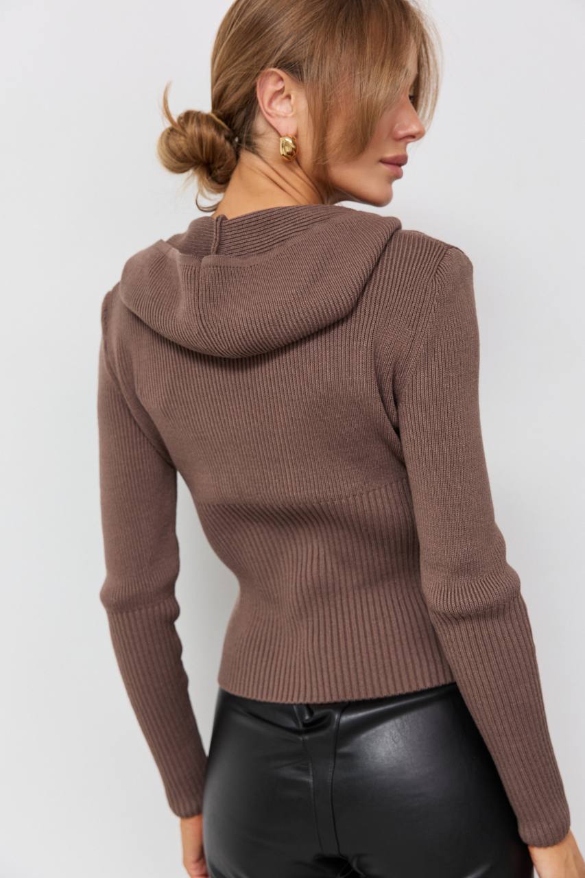 Brown ribbed sweater worn by a person on a white background