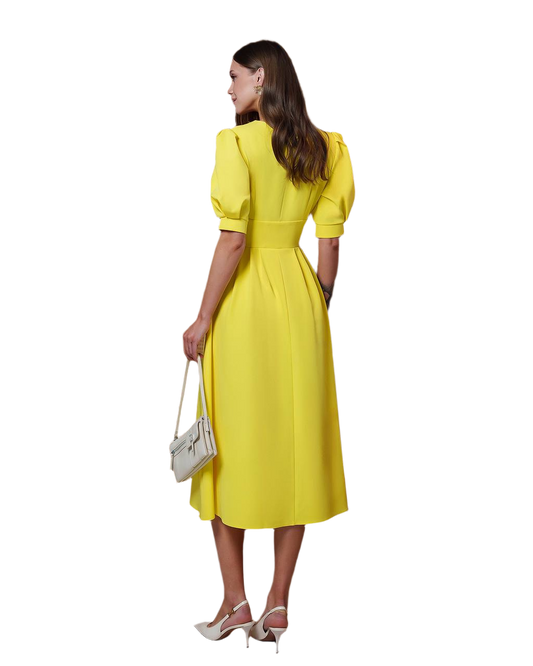 Woman wearing a yellow dress holding a white handbag on a white background