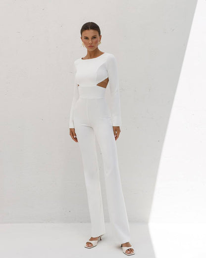 Woman wearing a white outfit with cut-out design on a plain background