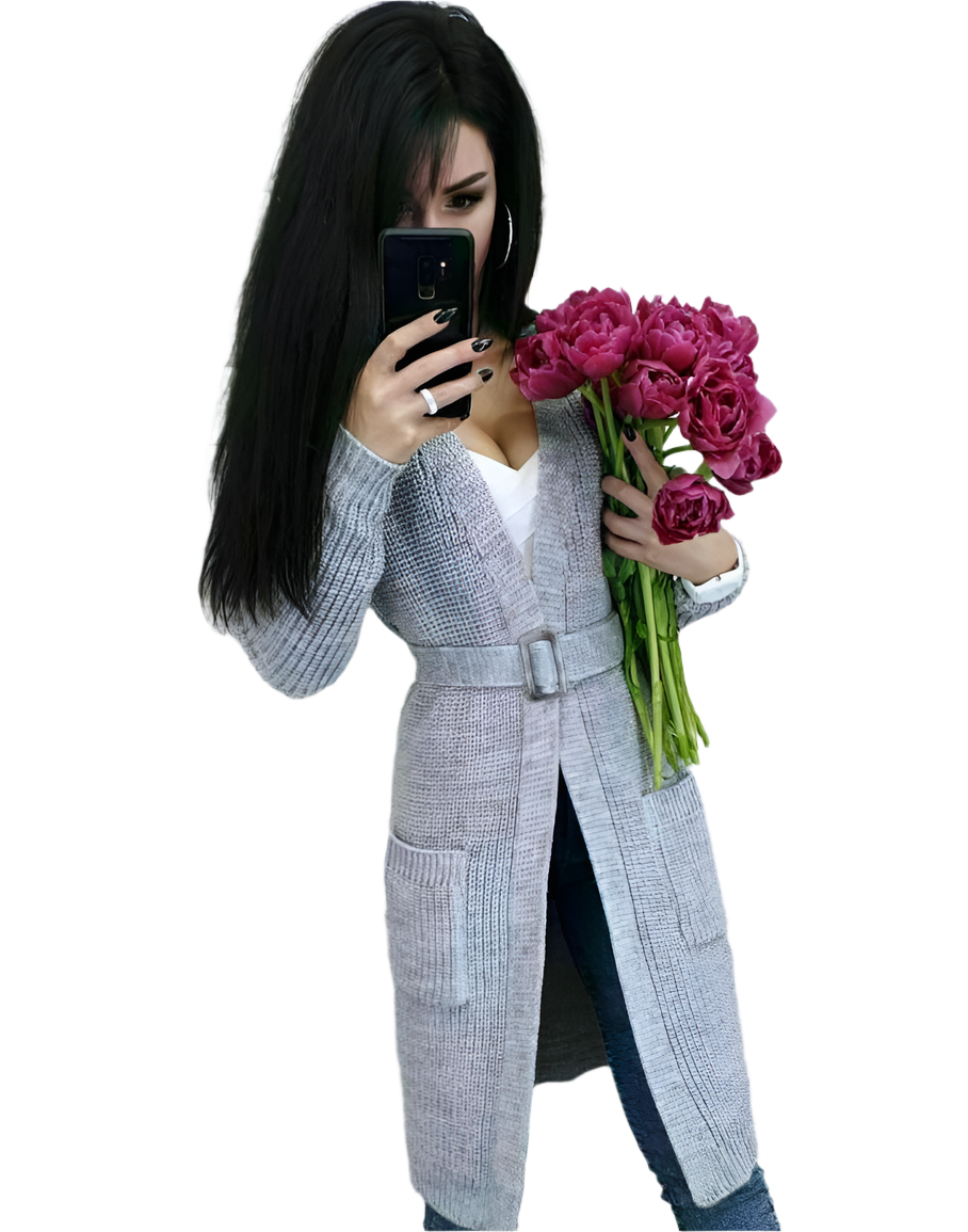 Woman in a gray coat holding pink flowers and a phone on a white background