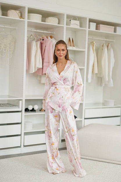 Woman in a floral pajama set standing in a well-organized closet.