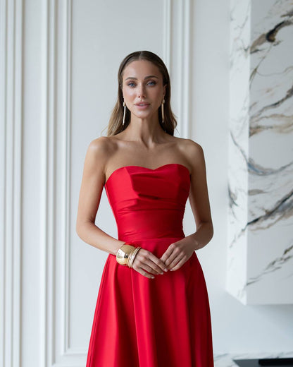Woman wearing a red strapless dress in an elegant interior setting