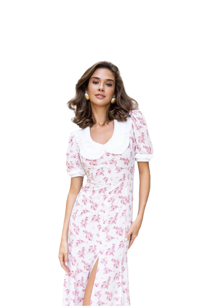 Woman wearing a white dress with pink floral pattern on a white background