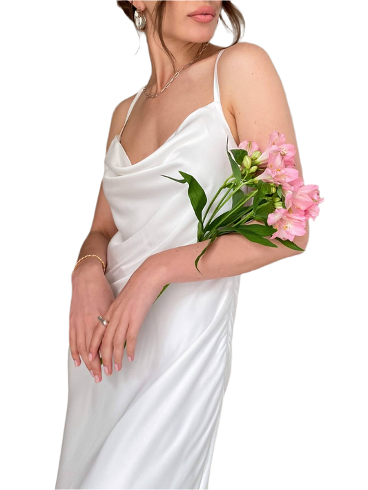 Woman in a white dress holding pink flowers against a white background