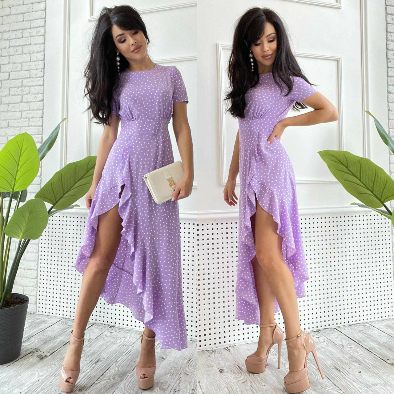 Woman wearing a purple dress with a white background and plants.