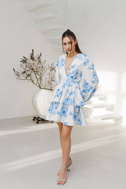 Woman wearing a blue floral dress in a minimalistic setting