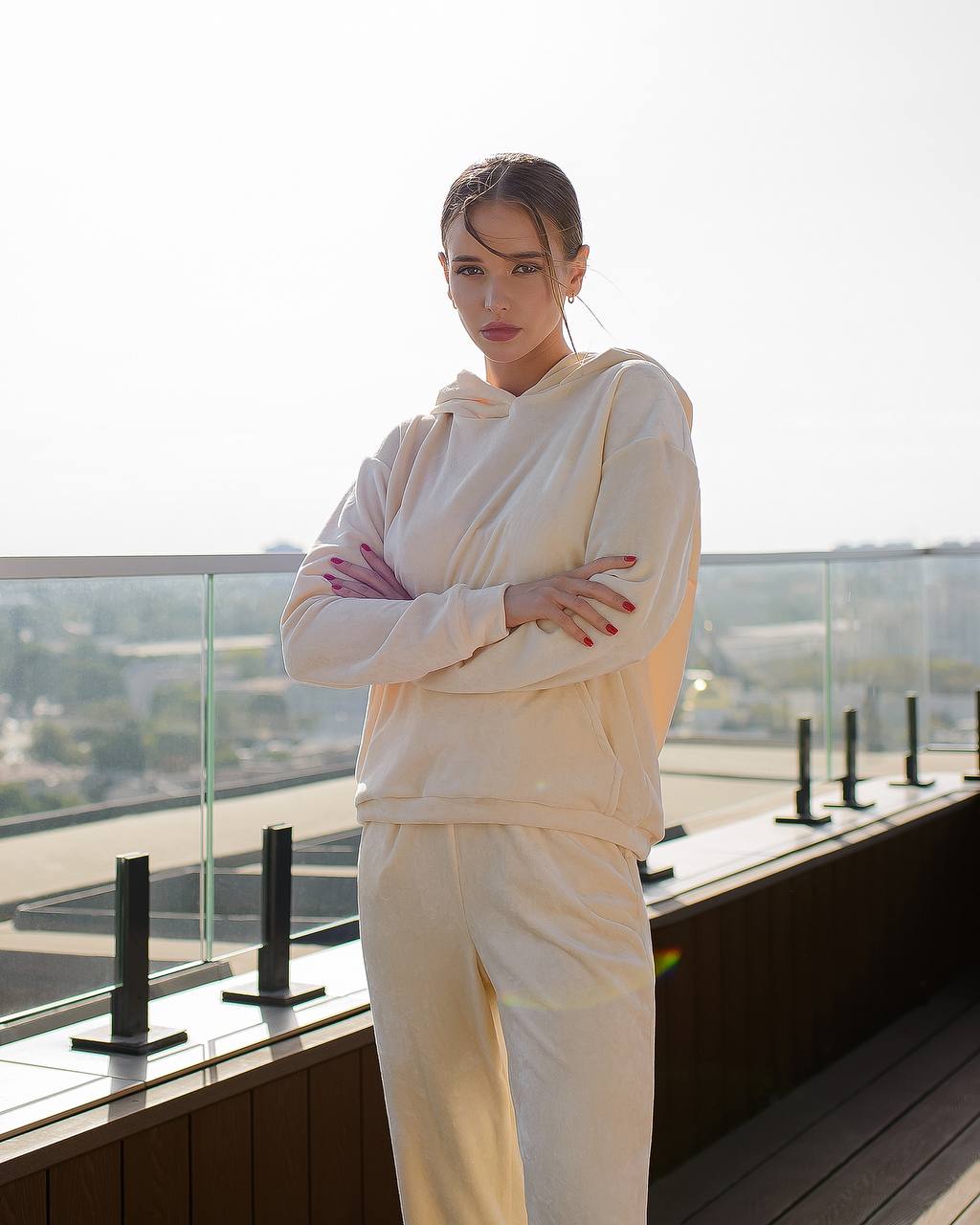 Woman in a white outfit standing on a rooftop with a cityscape view
