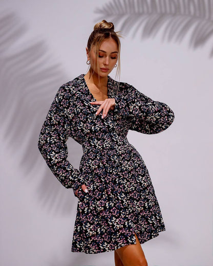 Woman wearing a floral dress against a plain background