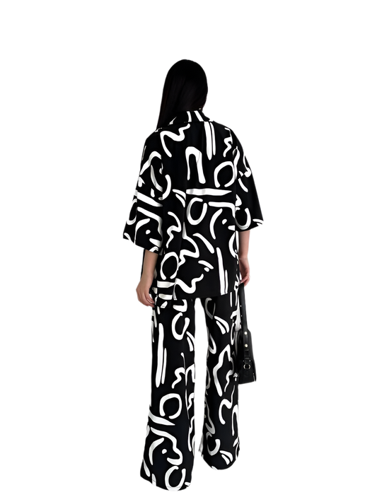 Person wearing a black outfit with white abstract patterns on a white background