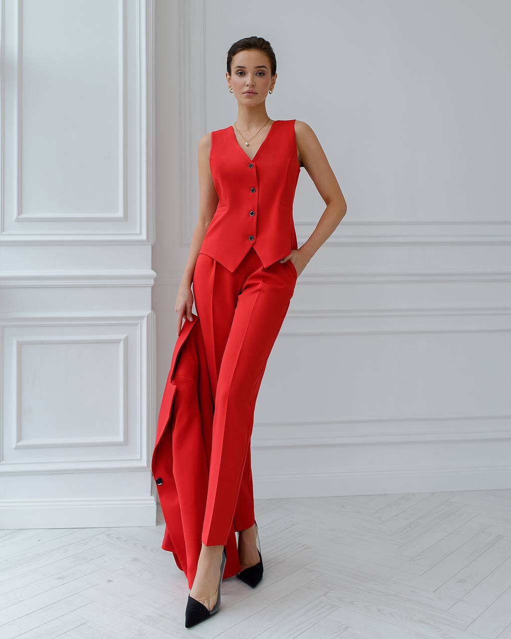 Woman wearing a red outfit with a white wall background