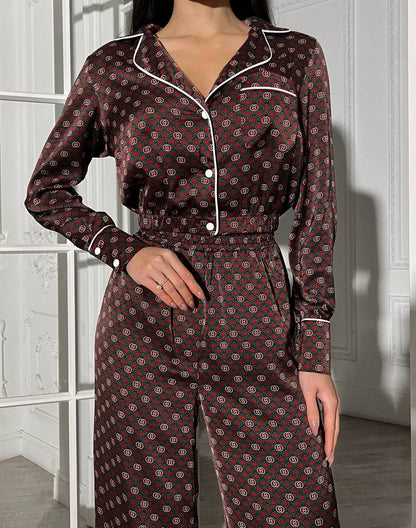 Person wearing a patterned pajama set in a room with white walls.