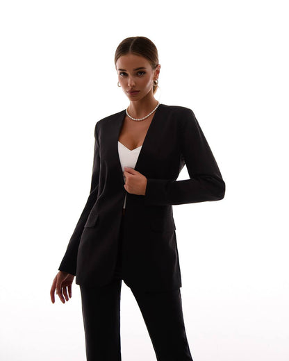 Woman wearing a black suit with a white top on a white background