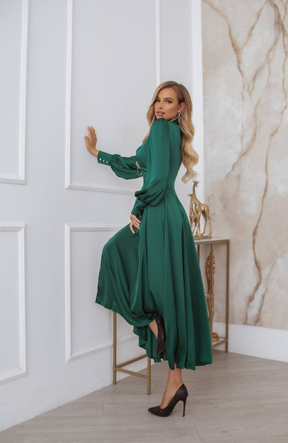 Woman in a green dress posing in a stylish interior setting