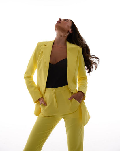 Woman wearing a bright yellow suit against a white background