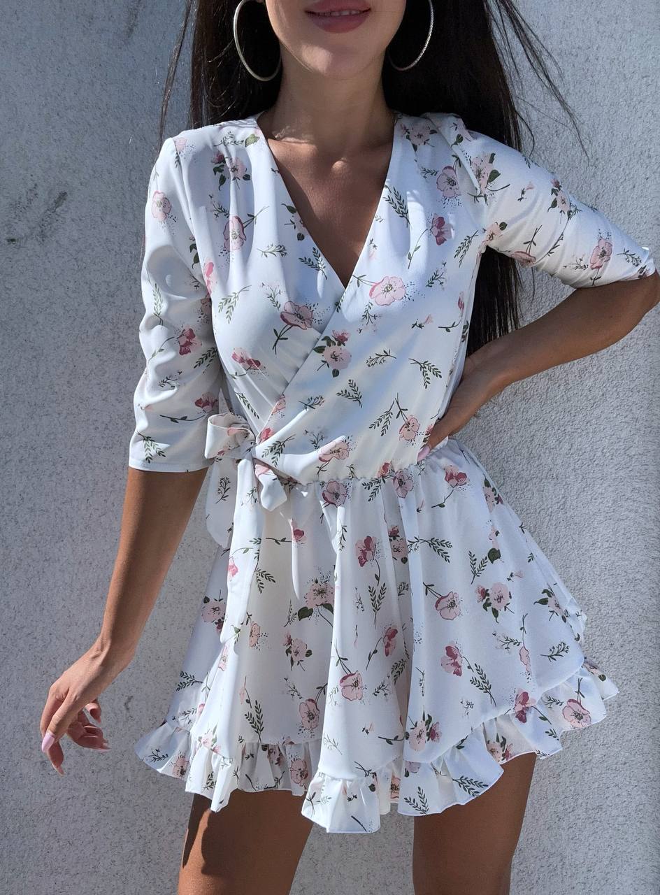 Woman wearing a floral dress against a gray background