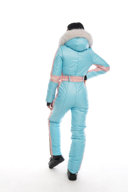 Person wearing a light blue snowsuit with pink accents on a white background