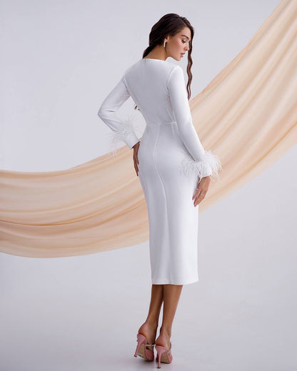 Woman wearing a white long-sleeve dress against a plain background