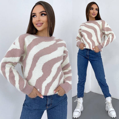 Woman wearing a striped sweater and jeans with white sneakers on a plain background