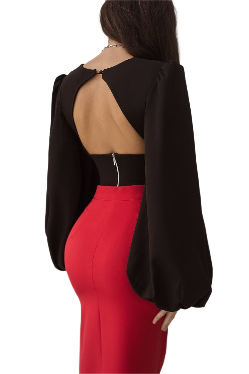 Person wearing a black open-back top and red pants on a white background