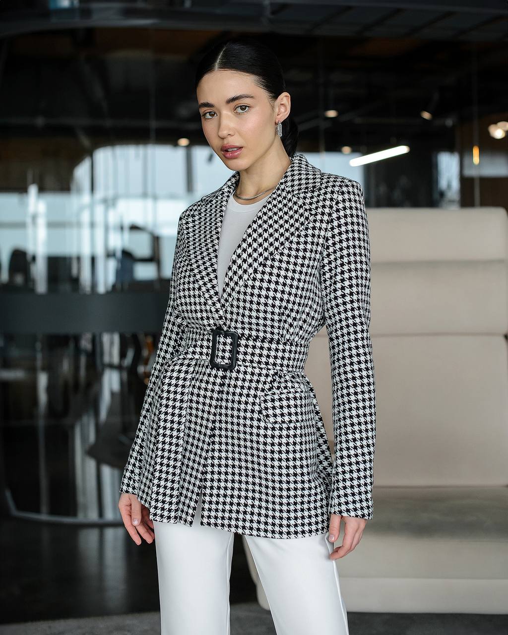 Woman wearing a black and white checkered blazer in an indoor setting