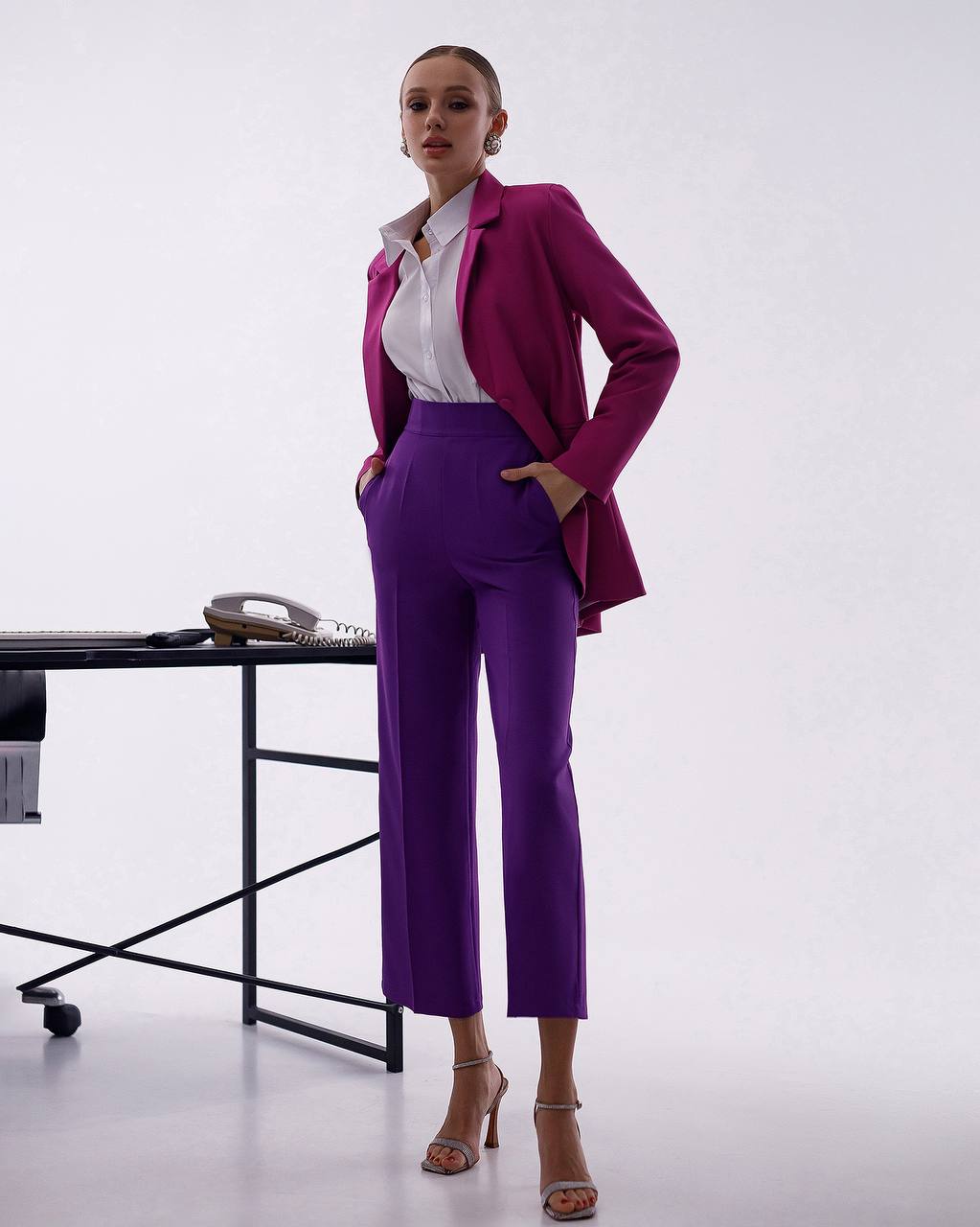Woman in a purple suit standing in an office setting