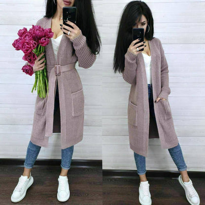 Woman wearing a long pink cardigan with a white background