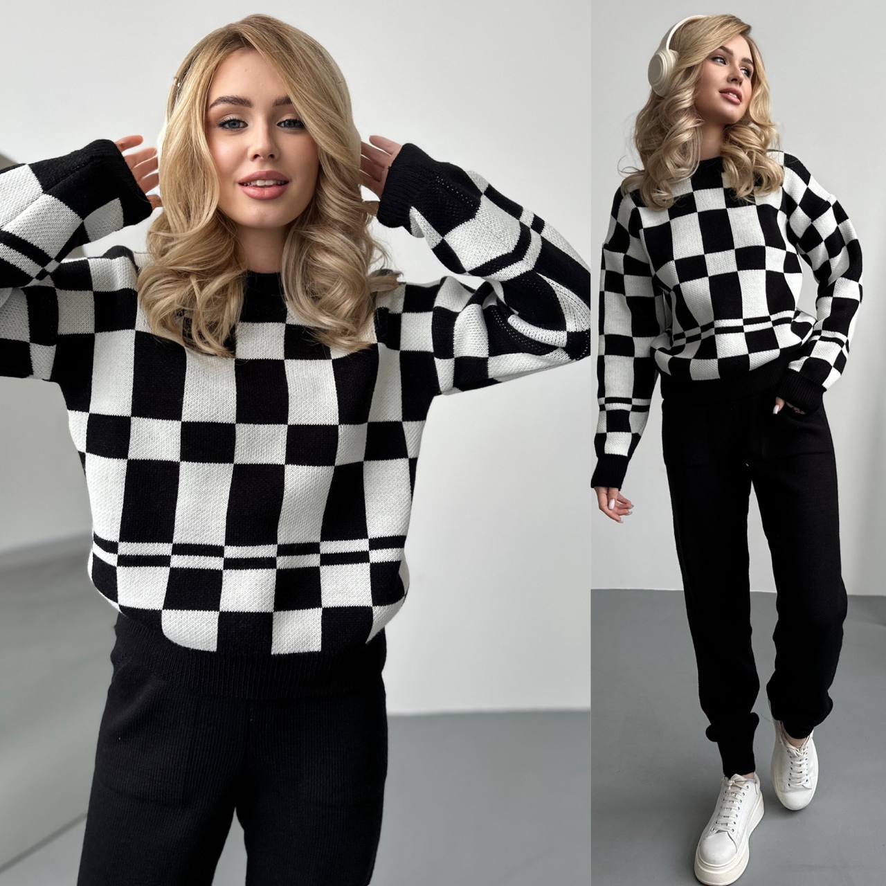 Woman wearing a black and white checkered sweater with a plain background