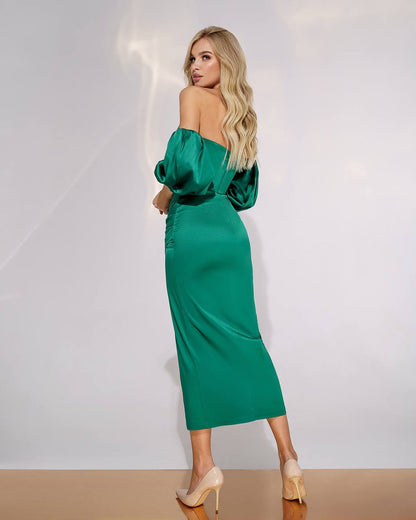 Woman wearing a green off-shoulder dress against a white background