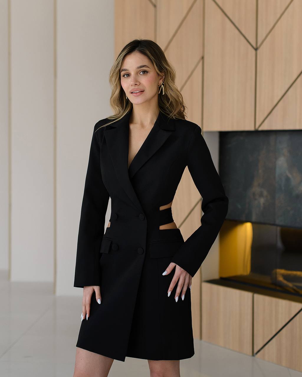 Woman wearing a black coat and skirt in an indoor setting