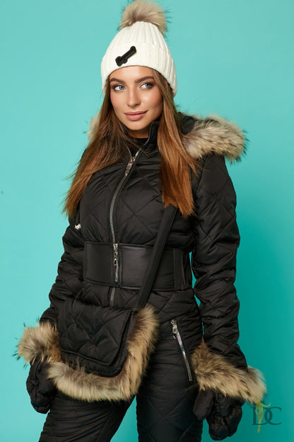 Person wearing a black puffer jacket with fur trim against a teal background