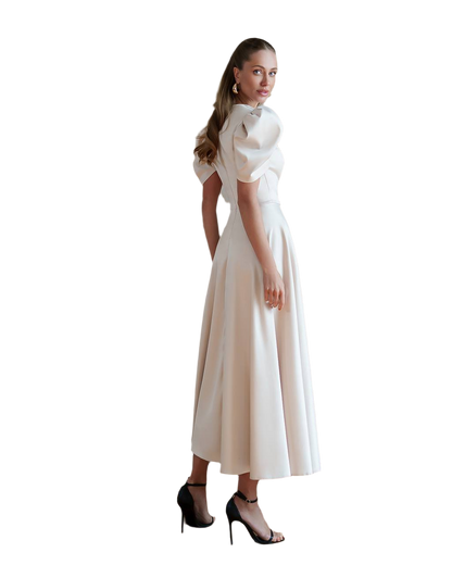 Woman wearing a white dress with a high collar on a white background