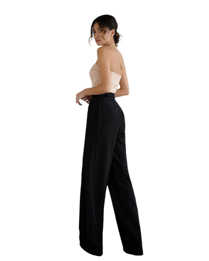 Woman wearing a strapless top and black pants on a white background