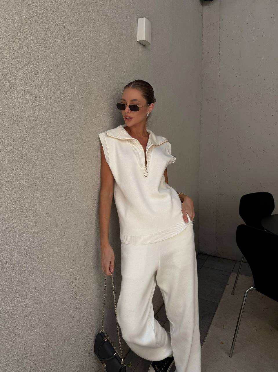 Person wearing a white outfit in a minimal indoor setting