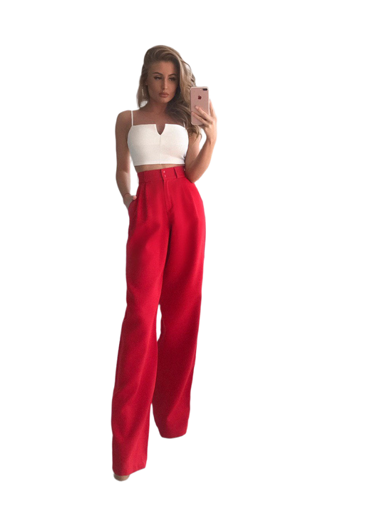 Woman wearing a white top and red pants on a white background