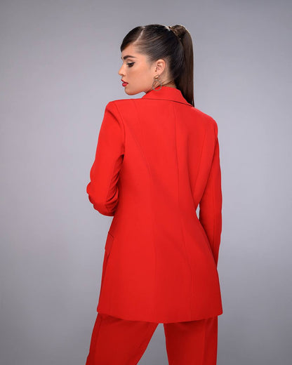 Woman wearing a red suit against a gray background