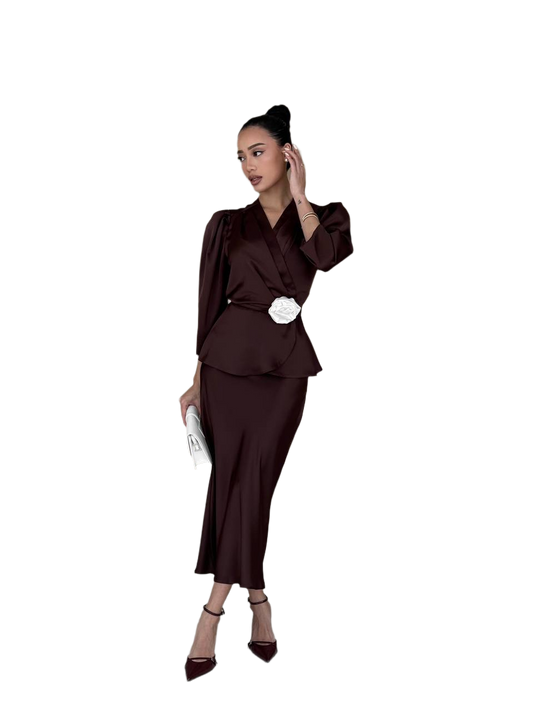 Woman wearing a brown outfit with a white belt on a white background