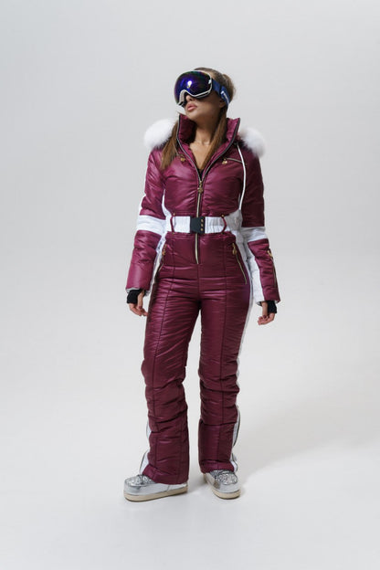Person wearing a maroon ski suit with white accents on a white background