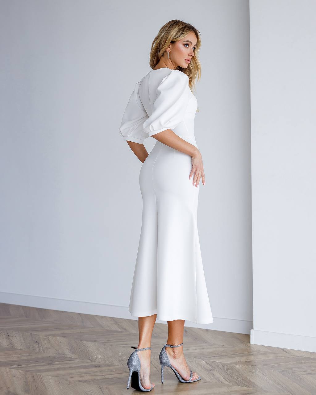 Woman wearing a white outfit against a plain background