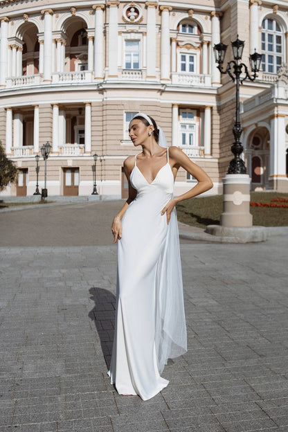 Woman in a white dress standing in front of a classical building