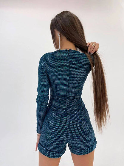 Person wearing a teal outfit with long sleeves and shorts on a white background