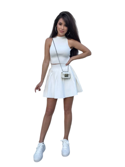 Woman wearing a white dress with a matching handbag on a white background