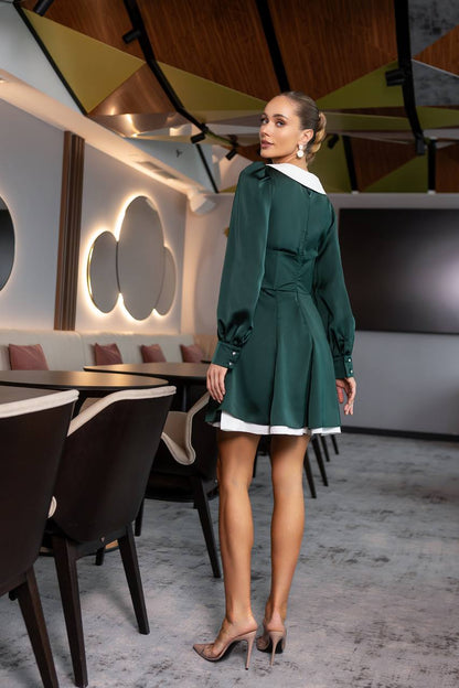 Woman in a green dress standing in a modern restaurant setting