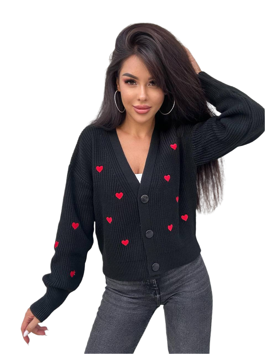 Woman wearing a black cardigan with red heart patterns on a white background