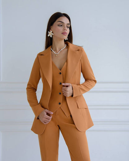 Woman wearing a mustard yellow suit against a white background