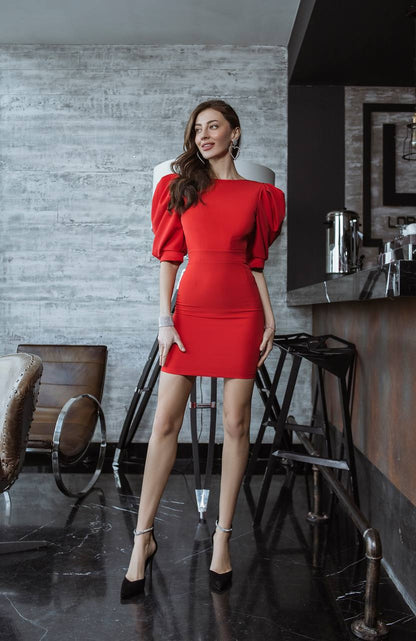 Woman in a red dress standing in a modern interior setting